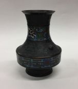 A brass and cloisonné vase decorated with bright c