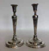 A pair of Georgian silver candlesticks on swirl su