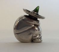 A novelty silver figure of a Mexican in seated pos