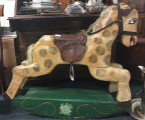 A wooden painted rocking horse with leather seat.