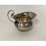 A small silver bachelor's cream jug of circular fo