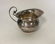 A small silver bachelor's cream jug of circular fo