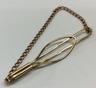 A small 9 carat tie clip with suspension chain. Ap