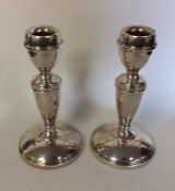 A pair of circular silver candlesticks on tapering