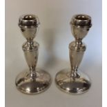 A pair of circular silver candlesticks on tapering