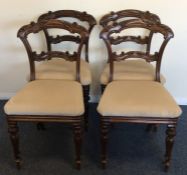 A set of four mahogany dining chairs decorated wit