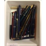 A box containing numerous Parker and other pens an