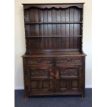 An oak panelled dresser with carved front to brack