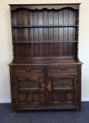 An oak panelled dresser with carved front to brack