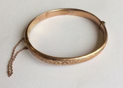 A 9 carat hinged bangle together with safety chain