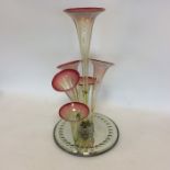 A cranberry glass six trumpet epergne on mirrored