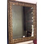 A large gilt mirror decorated with flowers. Est. £