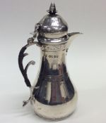 An attractive silver water jug decorated with scro