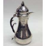 An attractive silver water jug decorated with scro