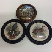 A group of three framed pot lids of various design