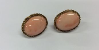 A pair of oval 18 carat coral earrings. Approx. 13