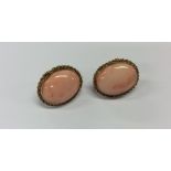 A pair of oval 18 carat coral earrings. Approx. 13