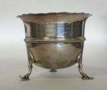 A silver sugar bowl with wavy edge on reeded suppo