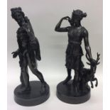 A pair of bronzed figures depicting hunters on cir