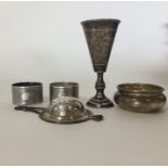 A small silver tea strainer together with napkin r