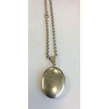 A heavy silver oval locket on fine link chain. App