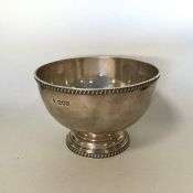 A circular silver rose bowl with gadroon rim on pe