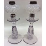 A pair of pale amethyst glass candlesticks together with twisted glass