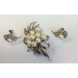 A pearl mounted brooch in the form of a flower tog