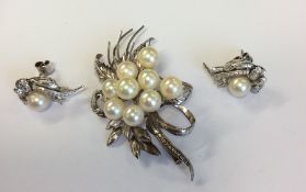 A pearl mounted brooch in the form of a flower tog