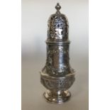 A Georgian silver caster attractively embossed wit