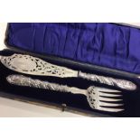 A boxed set of silver fish servers with pierced bl