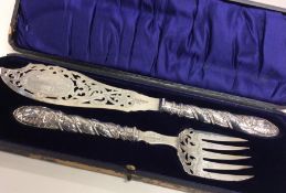 A boxed set of silver fish servers with pierced bl