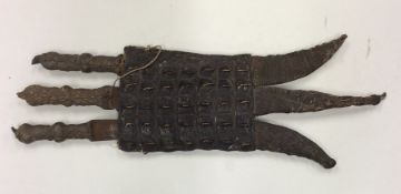 An unusual trio of daggers contained within a croc