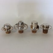 An unusual set of four silver plated wine stoppers