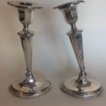 A pair of Edwardian silver tapering candlesticks w
