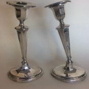 A pair of Edwardian silver tapering candlesticks w