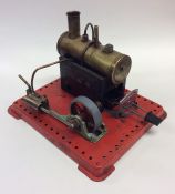 A small novelty brass steam engine on red painted