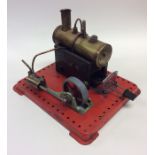 A small novelty brass steam engine on red painted