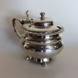 A Georgian circular silver mustard pot on ball fee