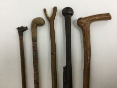 A group of walking sticks with carved decorations.