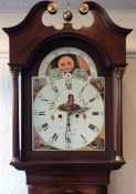 A large mahogany grandfather clock with canted cor