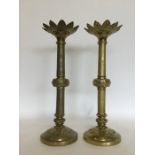 A pair of large Arts and Crafts brass candlesticks