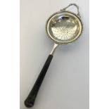 An Edwardian silver tea strainer with tapering han