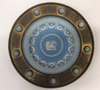 A 19th Century Wedgwood trophy plate in brass sur