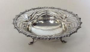 A circular silver pierced sweet dish decorated wit