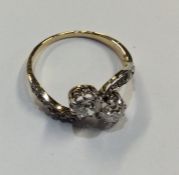 A good diamond two stone crossover ring in scroll