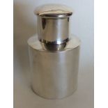 A small cylindrical silver tea caddy with lift-off