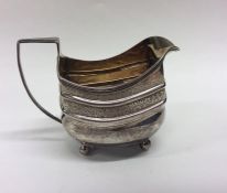 A Georgian bright cut silver cream jug decorated w