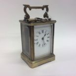A brass carriage clock with white enamelled dial o