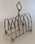 A heavy silver six bar toast rack on ball feet. Sh